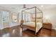This well lit bedroom includes hardwood floors, white curtains, and a wooden bed frame at 12 Broughton Rd, Charleston, SC 29407