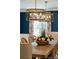Elegant dining room with table set with flowers, ornamental chandelier, and large window with decorative curtains at 12 Broughton Rd, Charleston, SC 29407