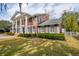 Stately brick home featuring manicured lawn, brick columns, and black shutters and roof at 12 Broughton Rd, Charleston, SC 29407