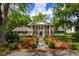 A distinguished brick home with white columns and symmetrical design, surrounded by mature trees at 12 Broughton Rd, Charleston, SC 29407