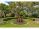 Exquisite landscaped garden with manicured hedges, colorful flowers, and a charming statue at 12 Broughton Rd, Charleston, SC 29407