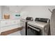 Clean laundry room boasts modern washer and dryer, white cabinets, and plenty of storage space at 12 Broughton Rd, Charleston, SC 29407