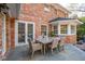 Outdoor seating area features a glass table and chairs for dining near a brick home at 12 Broughton Rd, Charleston, SC 29407