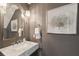 Stylish powder room featuring a marble countertop, elegant mirror, and modern lighting at 12 Broughton Rd, Charleston, SC 29407