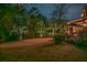 Backyard at night with a manicured lawn, landscaped trees, and inviting patio area under an umbrella at 1208 Wynnwood Ct, Mount Pleasant, SC 29464