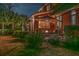 Backyard featuring a cozy patio area with an umbrella, landscaping, and an illuminated exterior at 1208 Wynnwood Ct, Mount Pleasant, SC 29464