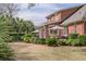 Large backyard with a brick home, a patio dining set, and mature trees, offering a peaceful outdoor space at 1208 Wynnwood Ct, Mount Pleasant, SC 29464