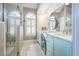 Bright bathroom features a double vanity with blue cabinets and a glass enclosed shower with decorative window at 1208 Wynnwood Ct, Mount Pleasant, SC 29464