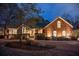 Captivating evening shot of a brick home with mature trees, manicured landscaping, and elegant lighting at 1208 Wynnwood Ct, Mount Pleasant, SC 29464