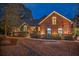 Brick home with manicured landscaping, curved windows, and a welcoming entryway at twilight at 1208 Wynnwood Ct, Mount Pleasant, SC 29464