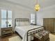 Comfortable bedroom with white bedding, wood floors, plantation shutters, and a decorative wrought iron bed frame at 127 Beresford Creek St, Charleston, SC 29492