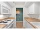 Galley kitchen features white cabinetry, modern appliances and earth-tone countertops and flooring at 1340 Pelican Watch Villas, Seabrook Island, SC 29455