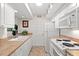 A well-lit narrow kitchen is finished with white appliances and cabinetry and earth-tone countertops at 1340 Pelican Watch Villas, Seabrook Island, SC 29455