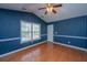 A primary bedroom with blue walls, hardwood floors, a ceiling fan, and a window at 140 Moon Shadow Ln, Summerville, SC 29485