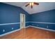 A primary bedroom with blue walls, white trim, hardwood floors, and a ceiling fan at 140 Moon Shadow Ln, Summerville, SC 29485