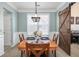 Charming dining room with a wooden table, chandelier, wainscoting, and a barn door at 1441 Thayer Pl, Mount Pleasant, SC 29466