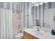 This cozy bathroom features a tub/shower combo, vanity, and striped wallpaper at 1473 Coopers Hawk Dr, Hanahan, SC 29410
