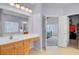 The light and airy main bathroom features a double vanity and a view into the main bedroom at 1473 Coopers Hawk Dr, Hanahan, SC 29410