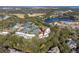Aerial view showcasing condo complex nestled within mature trees near tennis courts and a tranquil lake at 1614 Live Oak Park, Seabrook Island, SC 29455