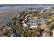 Aerial view showcases the condo complex nestled between waterways with tennis courts amidst a canopy of trees at 1614 Live Oak Park, Seabrook Island, SC 29455