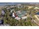 Aerial view displays a condo complex nestled amongst trees with tennis courts, a lake, and marshland nearby at 1614 Live Oak Park, Seabrook Island, SC 29455