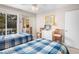 Bright bedroom featuring two beds with blue patterned linens, a mirrored closet, and sliding doors to the outside at 1614 Live Oak Park, Seabrook Island, SC 29455