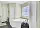 Relaxing bathroom with a large soaking tub, a window and a black fan at 162 Wal Flo Ln, Moncks Corner, SC 29461