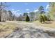 Rear view of a single-story home with a spacious yard surrounded by mature trees at 162 Wal Flo Ln, Moncks Corner, SC 29461