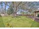 Spacious backyard featuring mature trees, a lush lawn, and a charming wooden deck at 1950 Culver Ave, Charleston, SC 29407