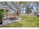 Landscaped backyard featuring a large tree, patio, table with chairs, and a well-manicured lawn at 1950 Culver Ave, Charleston, SC 29407