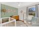 Charming Bedroom with a crib, dresser, and seating area bathed in soft natural light at 1950 Culver Ave, Charleston, SC 29407
