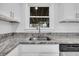 Close-up of a kitchen sink with granite countertops and white cabinets at 1950 Culver Ave, Charleston, SC 29407
