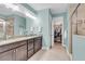 A modern bathroom with a double sink vanity, granite countertop, and walk-in closet at 2012 Barn Swallow Rd, Summerville, SC 29483