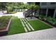 Backyard landscaped with pavers, artificial grass, and a swing-set providing outdoor enjoyment and visual appeal at 219 Forest Trl, Isle of Palms, SC 29451