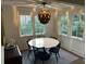 Bright dining room with modern light fixture, large windows, and a stylish round table for entertaining at 219 Forest Trl, Isle of Palms, SC 29451