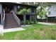 Home with stairs, artificial grass, and palm tree, creating a modern yet inviting outdoor space at 219 Forest Trl, Isle of Palms, SC 29451