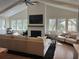 Bright living room features a fireplace, large windows, neutral decor, and hardwood floors for a cozy, inviting atmosphere at 219 Forest Trl, Isle of Palms, SC 29451