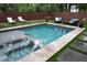 A luxurious pool with a spa and modern stone surround offers a perfect blend of relaxation and style at 219 Forest Trl, Isle of Palms, SC 29451
