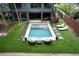 A pristine pool is surrounded by lush turf, modern pavers and lounge seating, creating an inviting backyard retreat at 219 Forest Trl, Isle of Palms, SC 29451