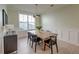Inviting dining area featuring stylish black chairs, light-wood table, modern light fixture, and ample natural light at 2317 Chisol Plow St, Mount Pleasant, SC 29466