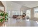 Spacious living room with light wood floors, high ceilings, and abundant natural light from large windows at 2317 Chisol Plow St, Mount Pleasant, SC 29466