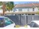 View of townhouse exteriors featuring a parking area with privacy fence and palm trees at 2416 Kings Gate Ln # 403, Mount Pleasant, SC 29466