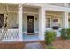 Inviting front porch with decorative wreath, flowers, and white columns at 2416 Kings Gate Ln # 403, Mount Pleasant, SC 29466