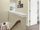 Open hallway with wood banister, trim, and neutral paint, adjacent to a bright, carpeted room at 2416 Kings Gate Ln # 403, Mount Pleasant, SC 29466