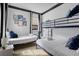 Cozy bedroom features a bunk bed, a twin bed with white linen, art decor and bright natural light at 263 St Philip St, Charleston, SC 29403
