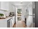 Modern, all-white kitchen with stainless steel appliances and view to backyard through open door at 2714 W Surrey Dr, North Charleston, SC 29405