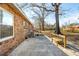 Backyard patio area with a wooden bench, backing up to the brick house at 28 Elmora Ave, Goose Creek, SC 29445