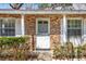 Charming brick home with a white front door, windows, and lush green bushes at 28 Elmora Ave, Goose Creek, SC 29445