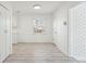 A bright hallway with gray wood-look floors, contrasting brick accent wall, and white painted paneling at 28 Elmora Ave, Goose Creek, SC 29445