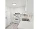 Vintage style kitchen featuring white appliances, cabinetry, and wood-look flooring at 28 Elmora Ave, Goose Creek, SC 29445